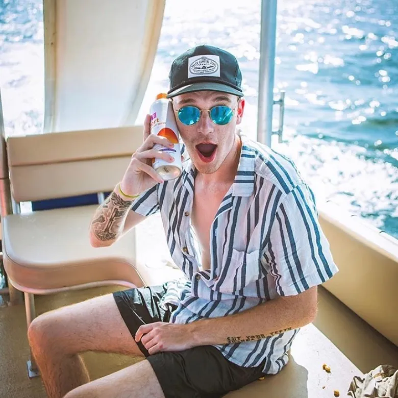 a person wearing a hat and sunglasses sitting on a table