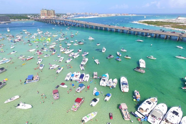 a crowded beach next to a body of water