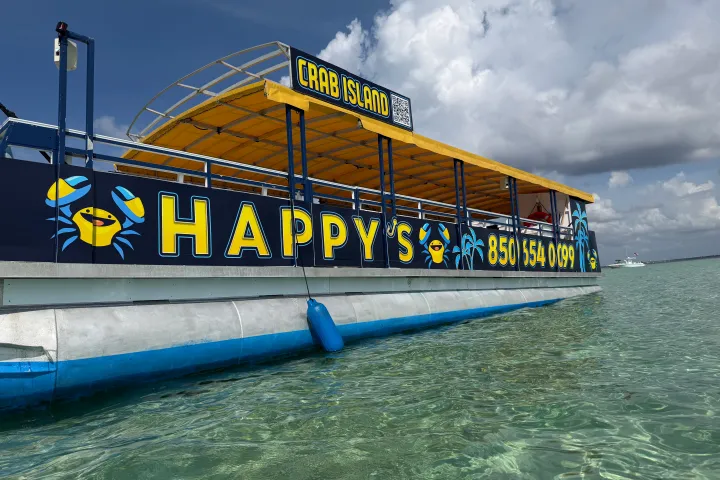 Floating bar named 'Happy's' on water, sunny sky.