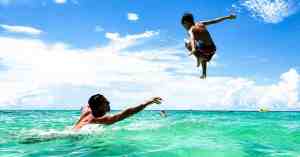 A father and son playing in the ocean together