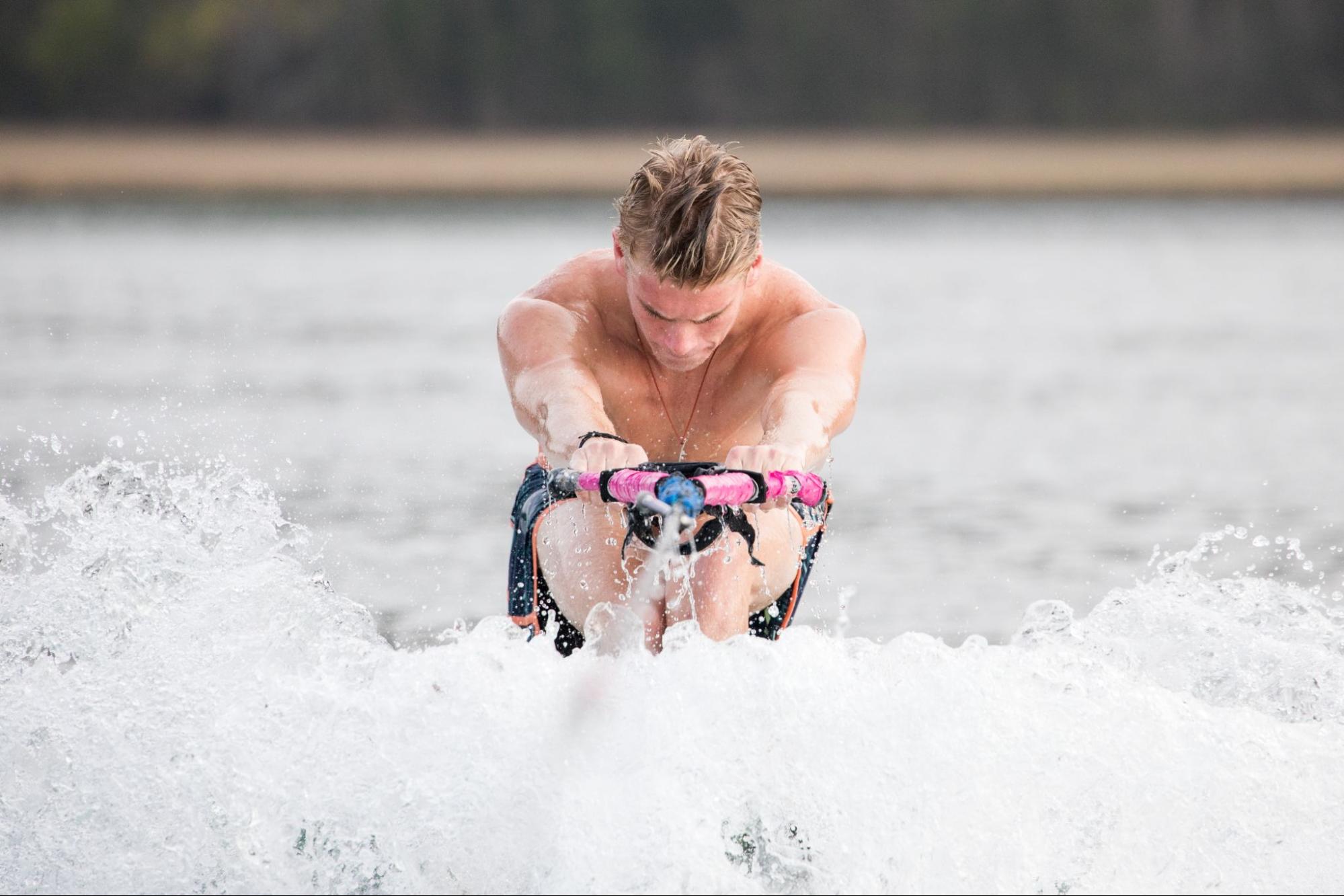 A man focusing on balancing while water skiing.