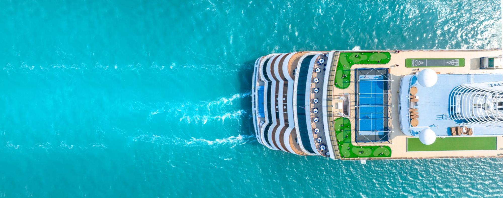 A luxurious white cruise ship sailing smoothly on the blue ocean.