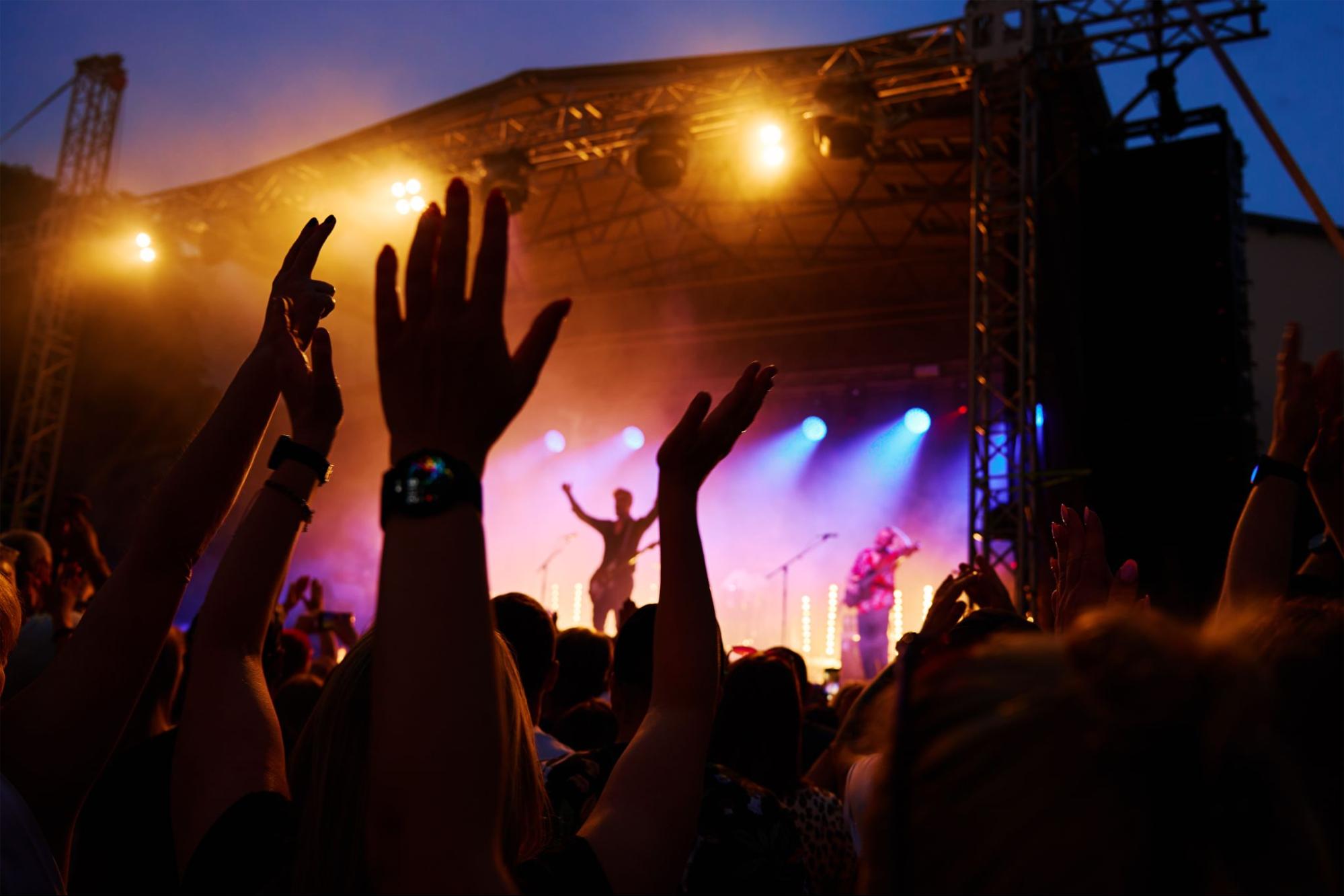 People’s hands in the air at a music festival 