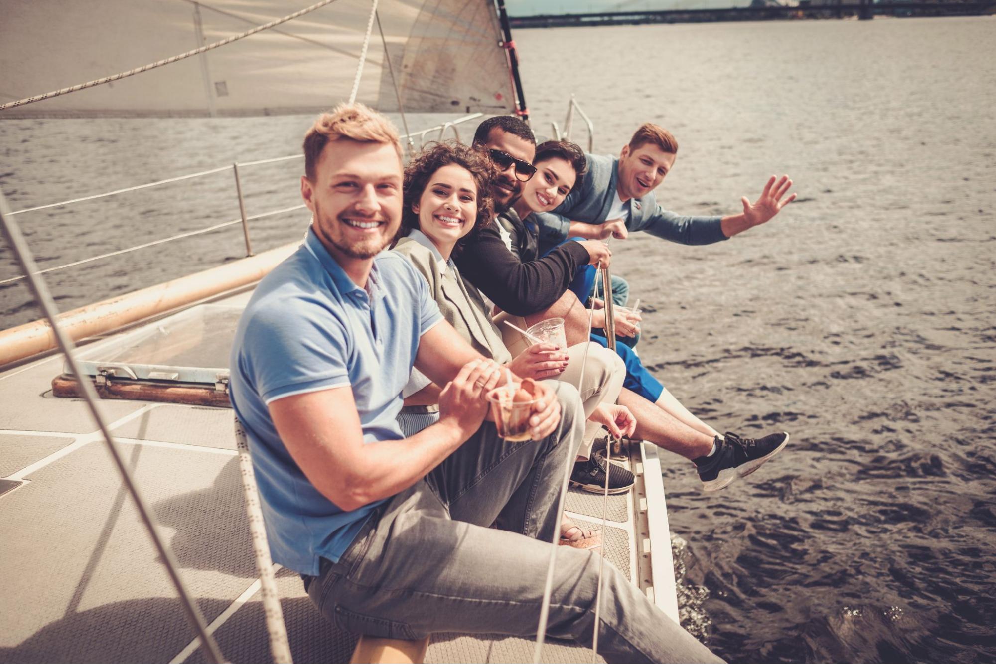 A group of happy friends relaxing on a yacht, enjoying the open water and sunny weather.