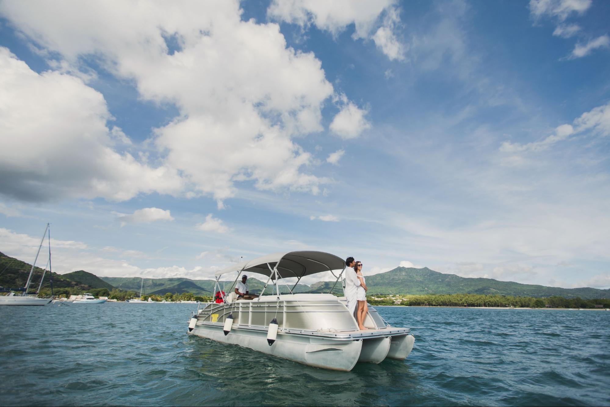 A young couple on a pontoon boat. 